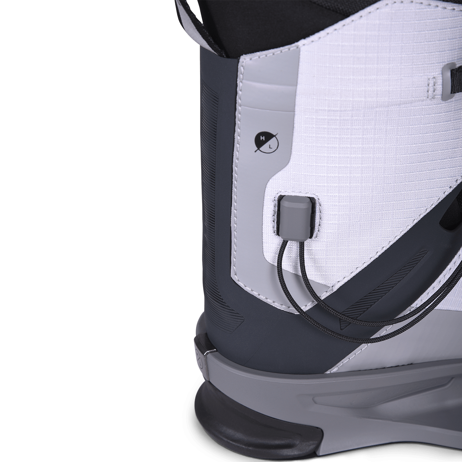Close-up of a white and black snowboarding boot with cable dial adjustment system.
